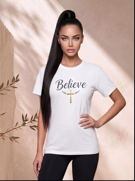 Woman wearing a white t-shirt with 'Believe' and a cross design on a beige background