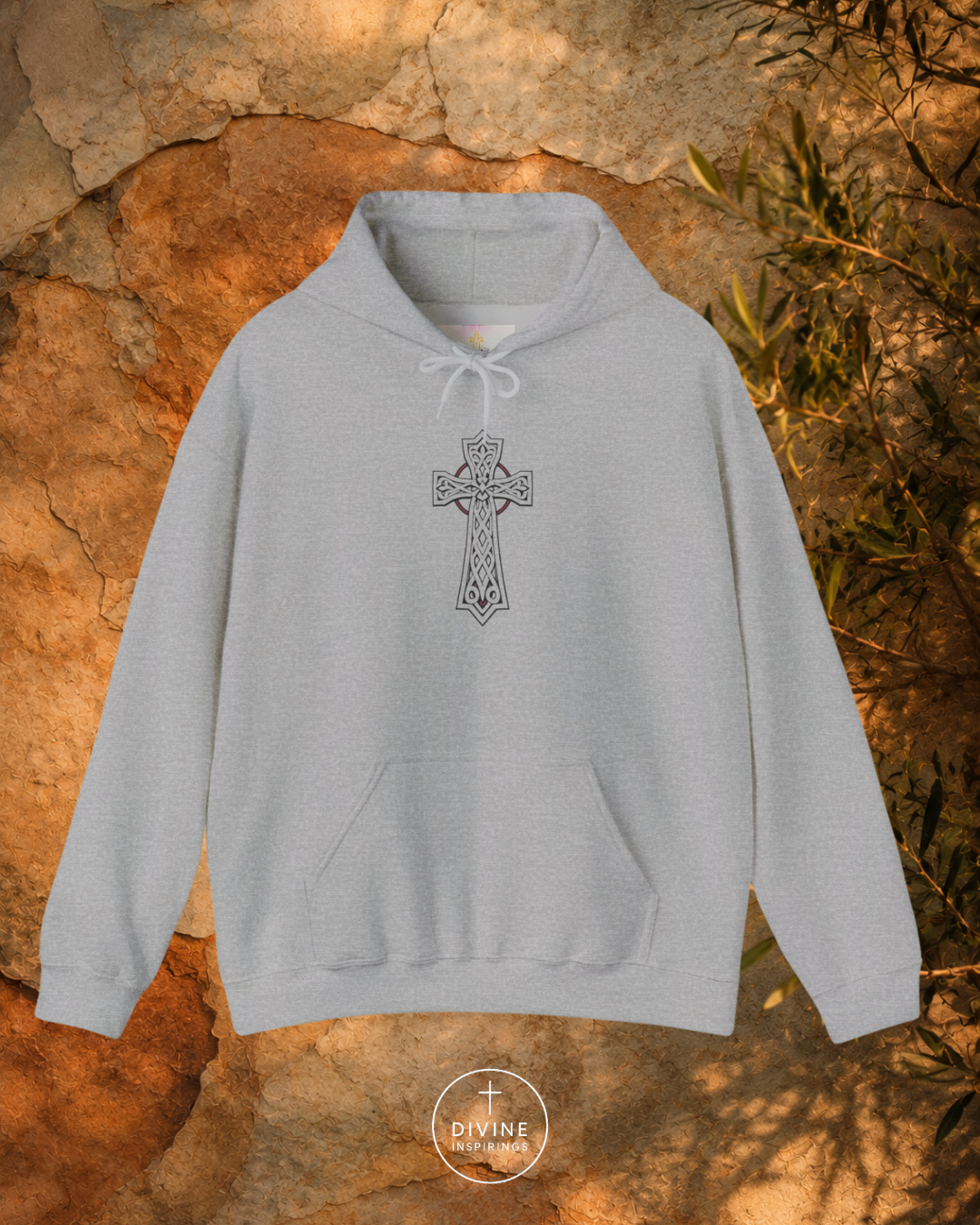 Gray hoodie with a cross design on a stone surface
