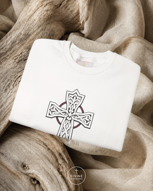 White sweatshirt with a Celtic cross design on a textured beige fabric background