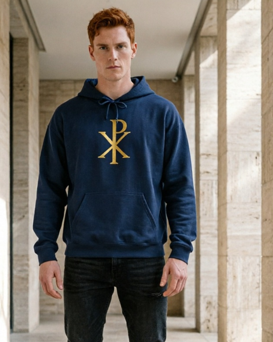 Man wearing a blue hoodie with a gold logo in an architectural setting