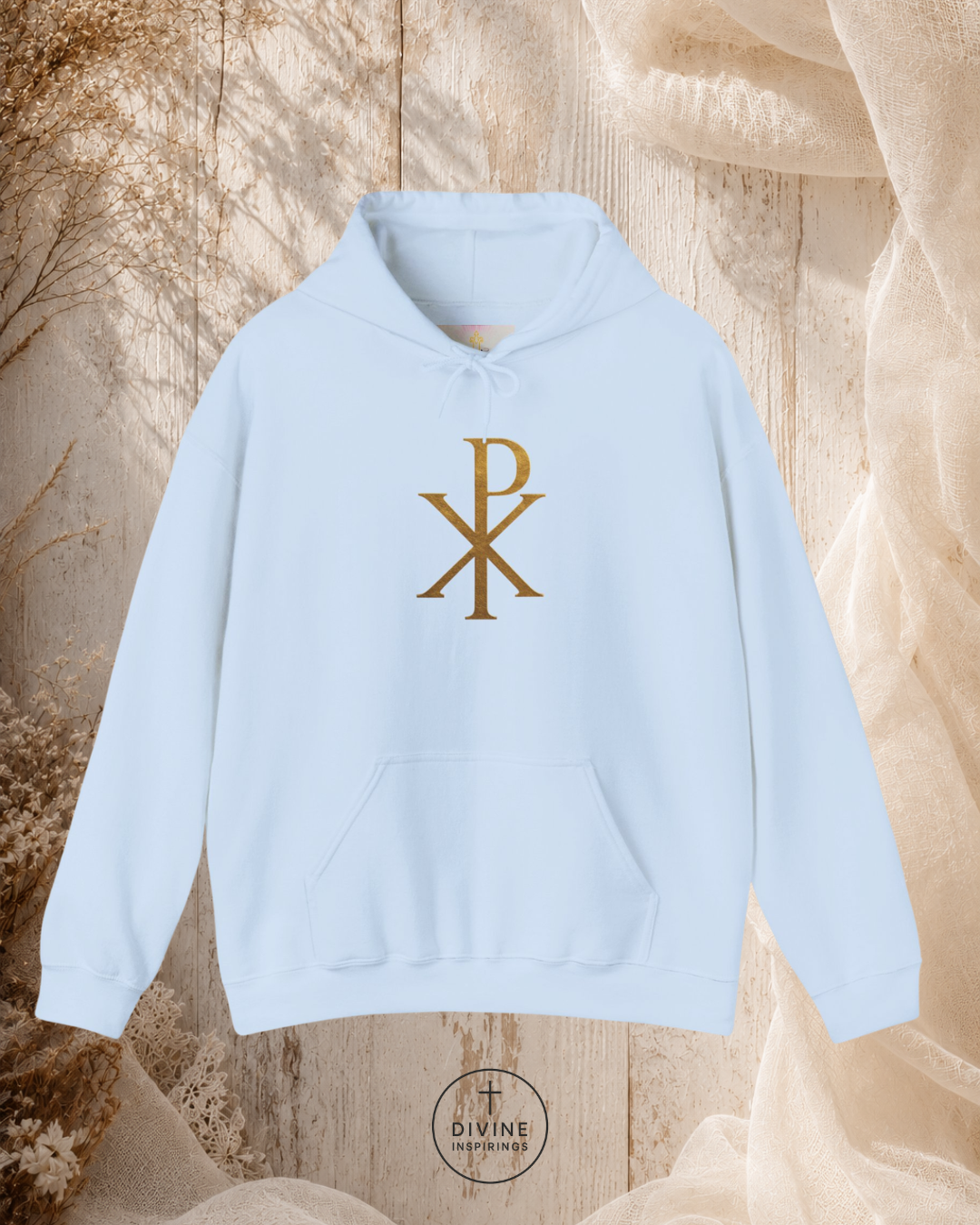 Light blue hoodie with gold symbol on a textured beige background