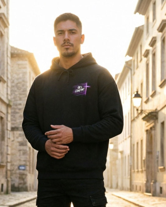 Man wearing a black hoodie with a logo on a street