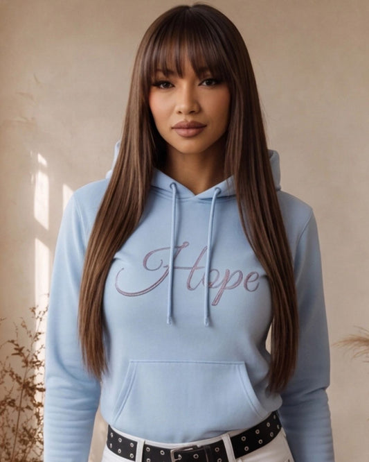 Woman wearing a light blue hoodie with 'Hope' printed on it against a beige background