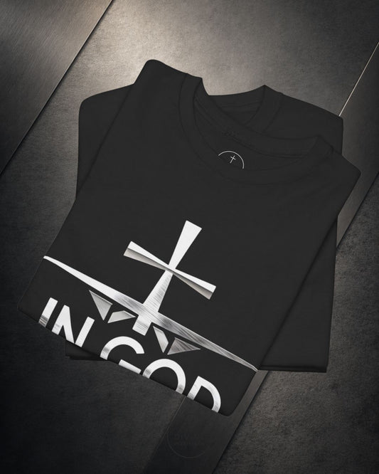 Black hoodie with a white cross and 'IN GOD' text on a dark surface