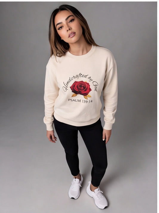 Woman wearing a beige sweatshirt with a red rose graphic and text on a gray background