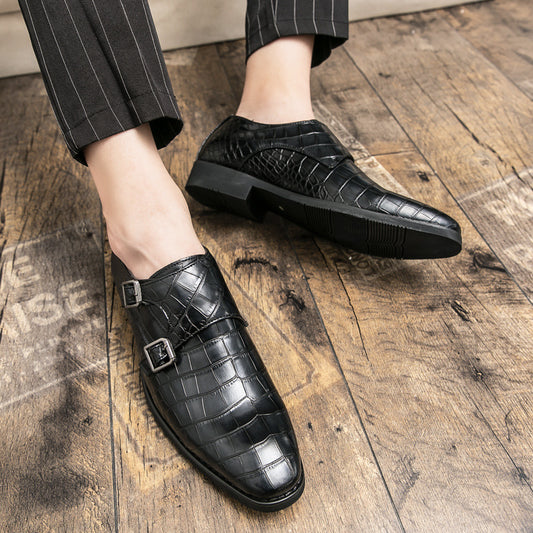 Black leather shoes with buckle details on a wooden floor