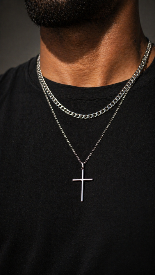 Silver chain necklace with a cross pendant on a black shirt