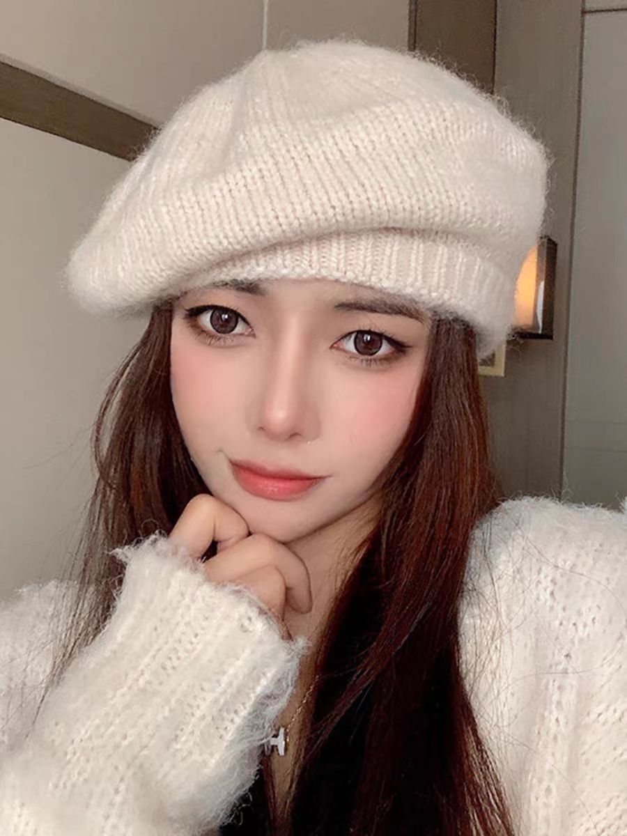 Person wearing a white knit hat and sweater indoors