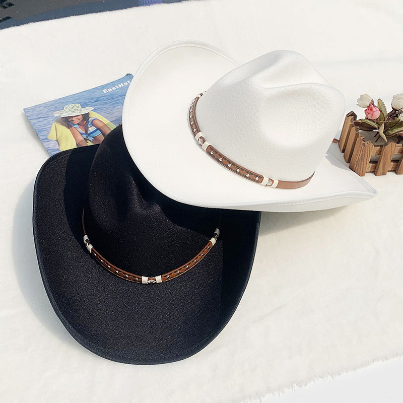 Two hats, one black and one white, with brown bands on a white surface.