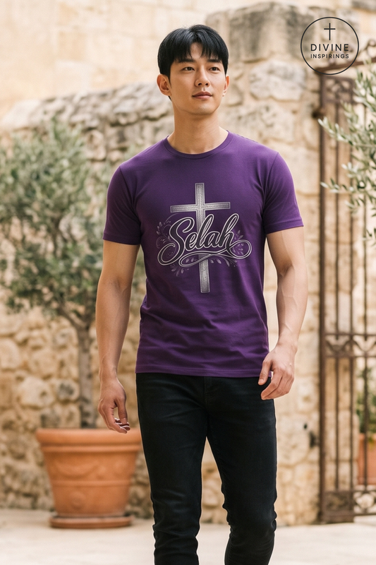 A man wearing a purple t-shirt with a silver cross and 'Selah' graphic, standing in front of a rustic stone wall background. A 'DIVINE INSPIRINGS' logo is visible in the top right corner.