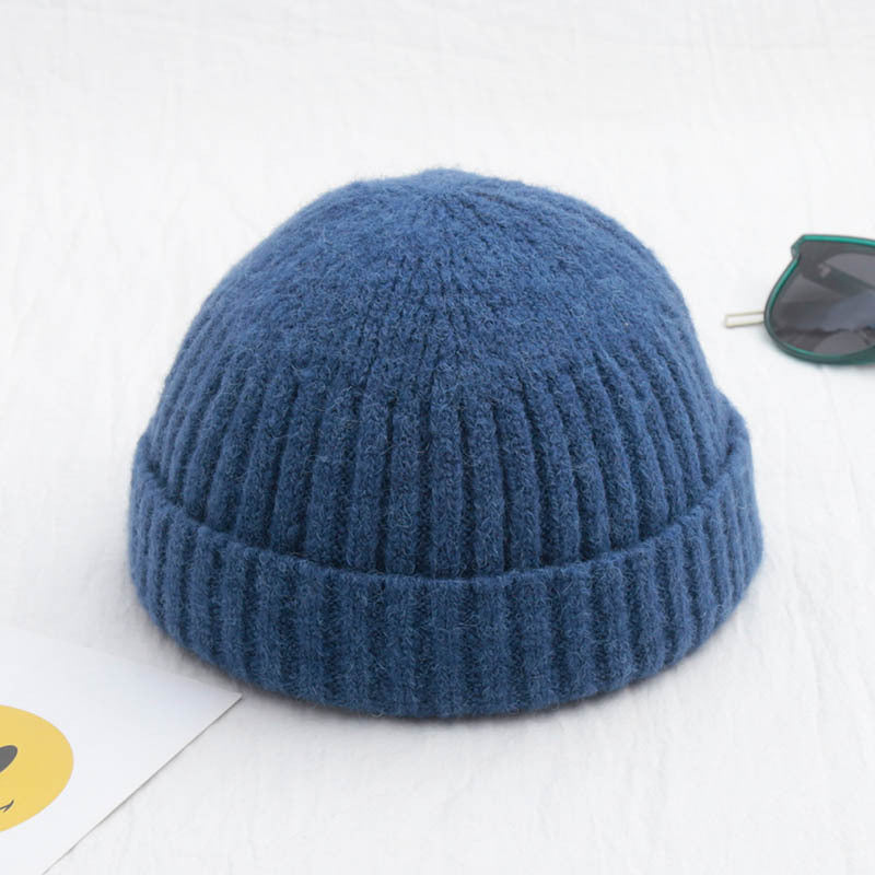 Blue knitted beanie on a light gray background