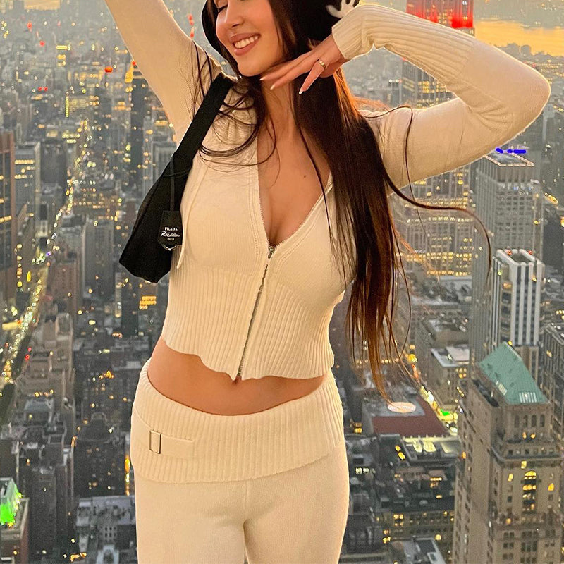Woman in a beige outfit posing with a cityscape background