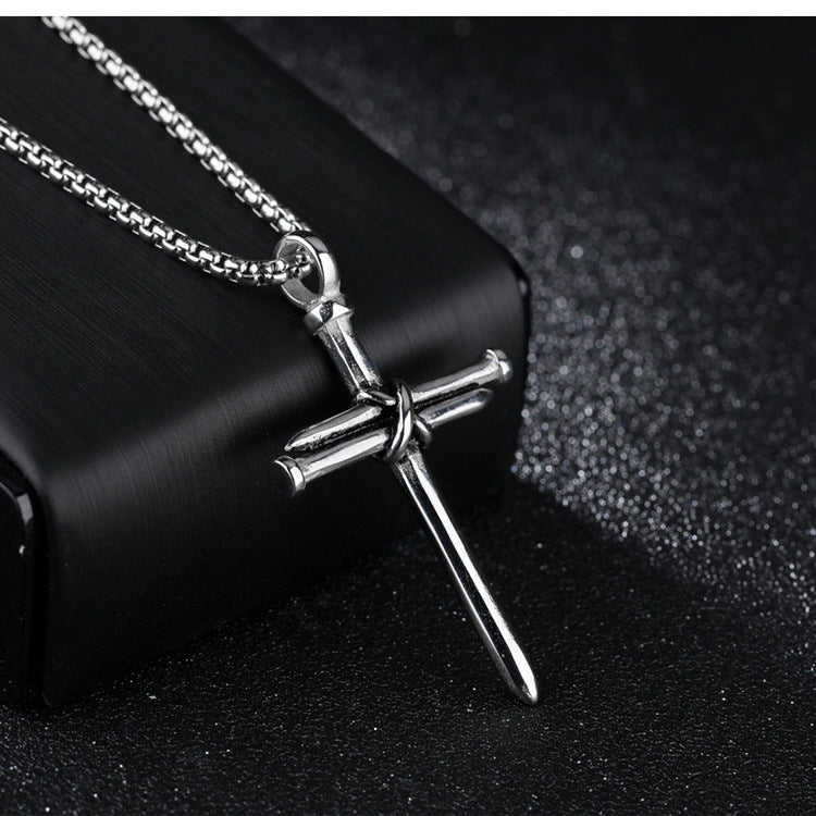Silver cross necklace with chain on a black background