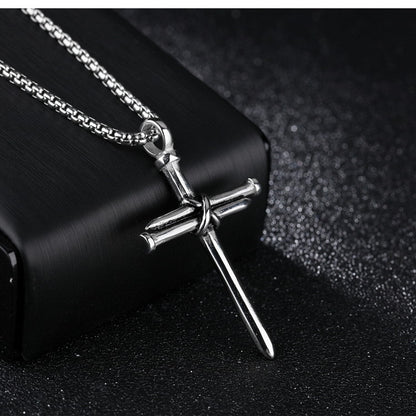 Silver cross necklace with chain on a black background