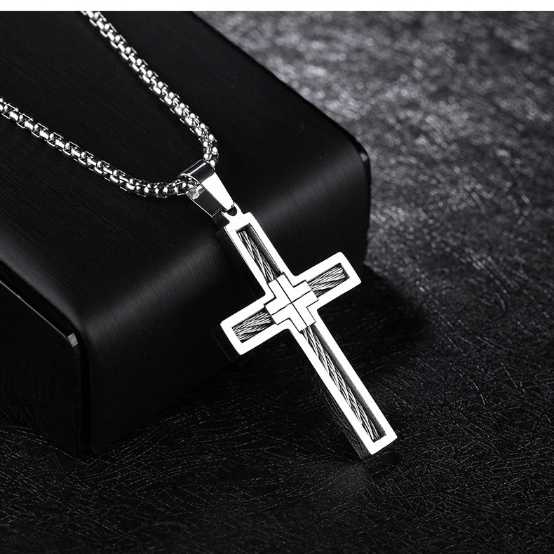 Silver cross pendant necklace on a dark textured background
