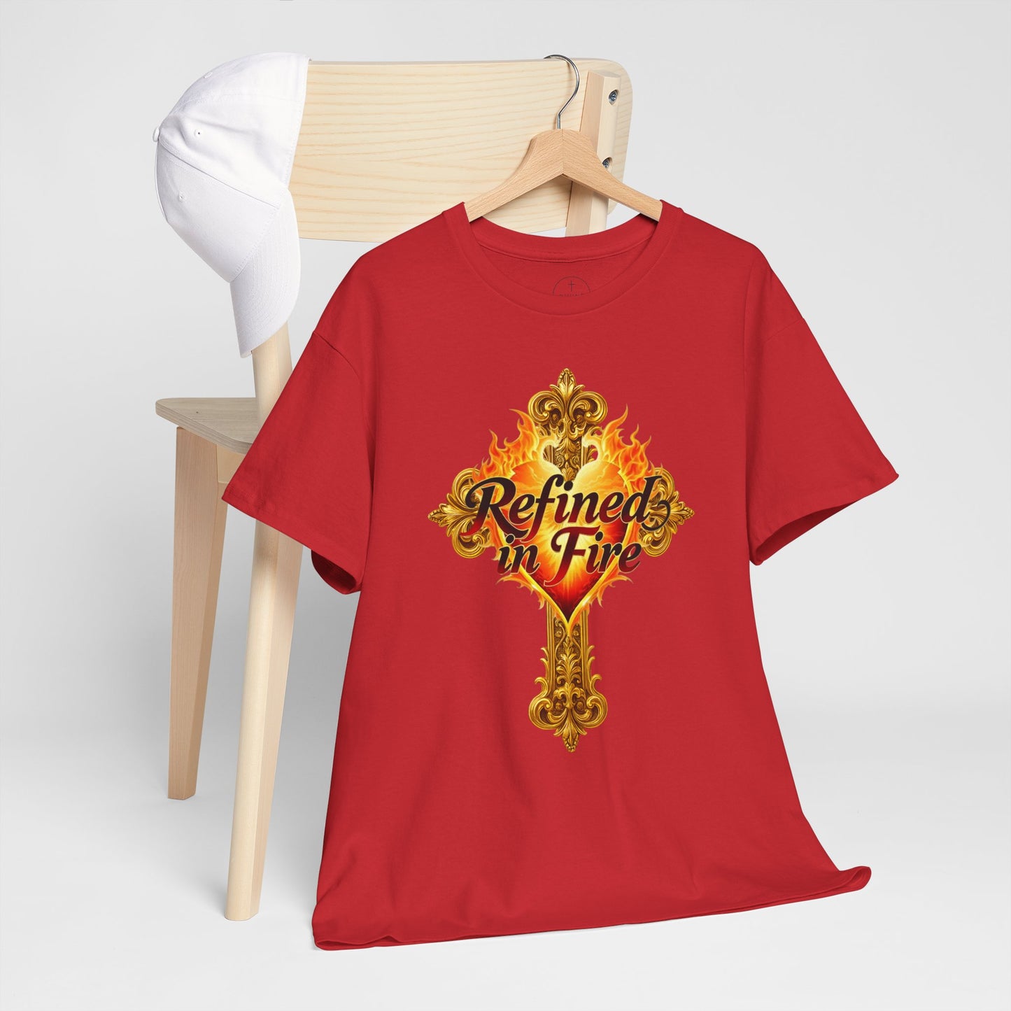 Red t-shirt with 'Refined in Fire' design on a wooden hanger against a white background