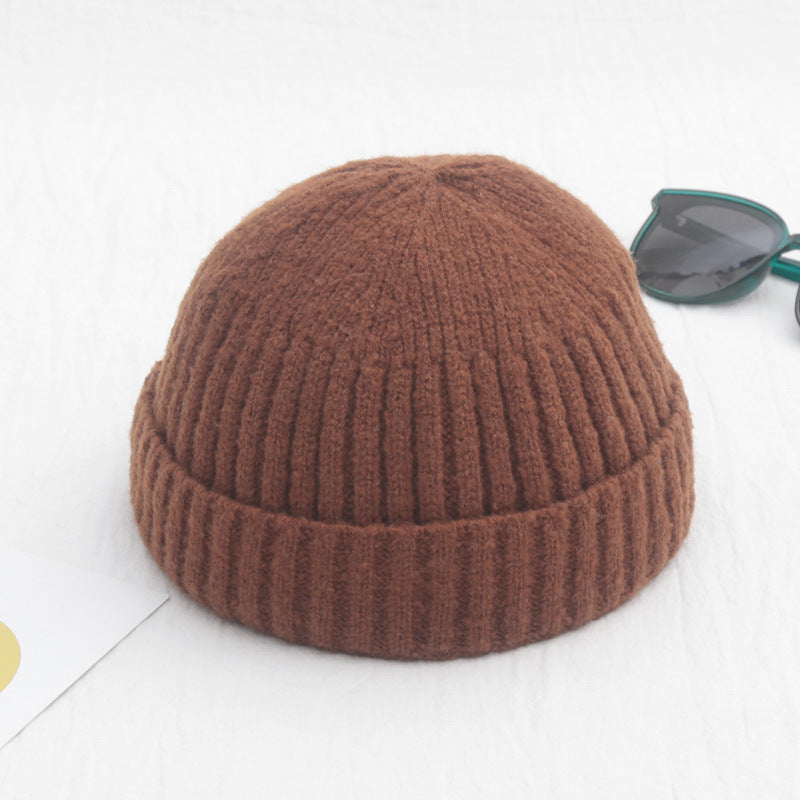 Brown knitted beanie on a white background