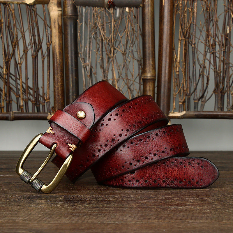 Two red leather belts with gold buckles on a wooden surface.