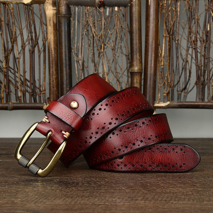Two red leather belts with gold buckles on a wooden surface.