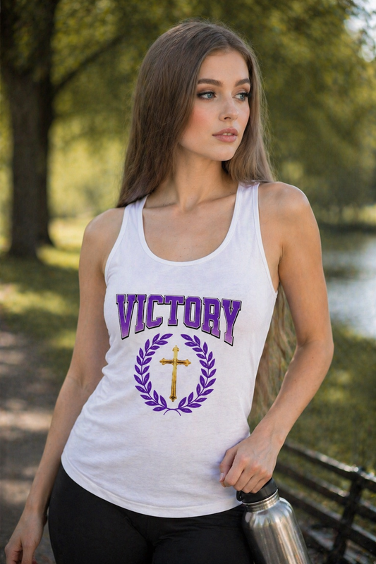 Woman wearing a white tank top with 'VICTORY' and a cross design outdoors.
