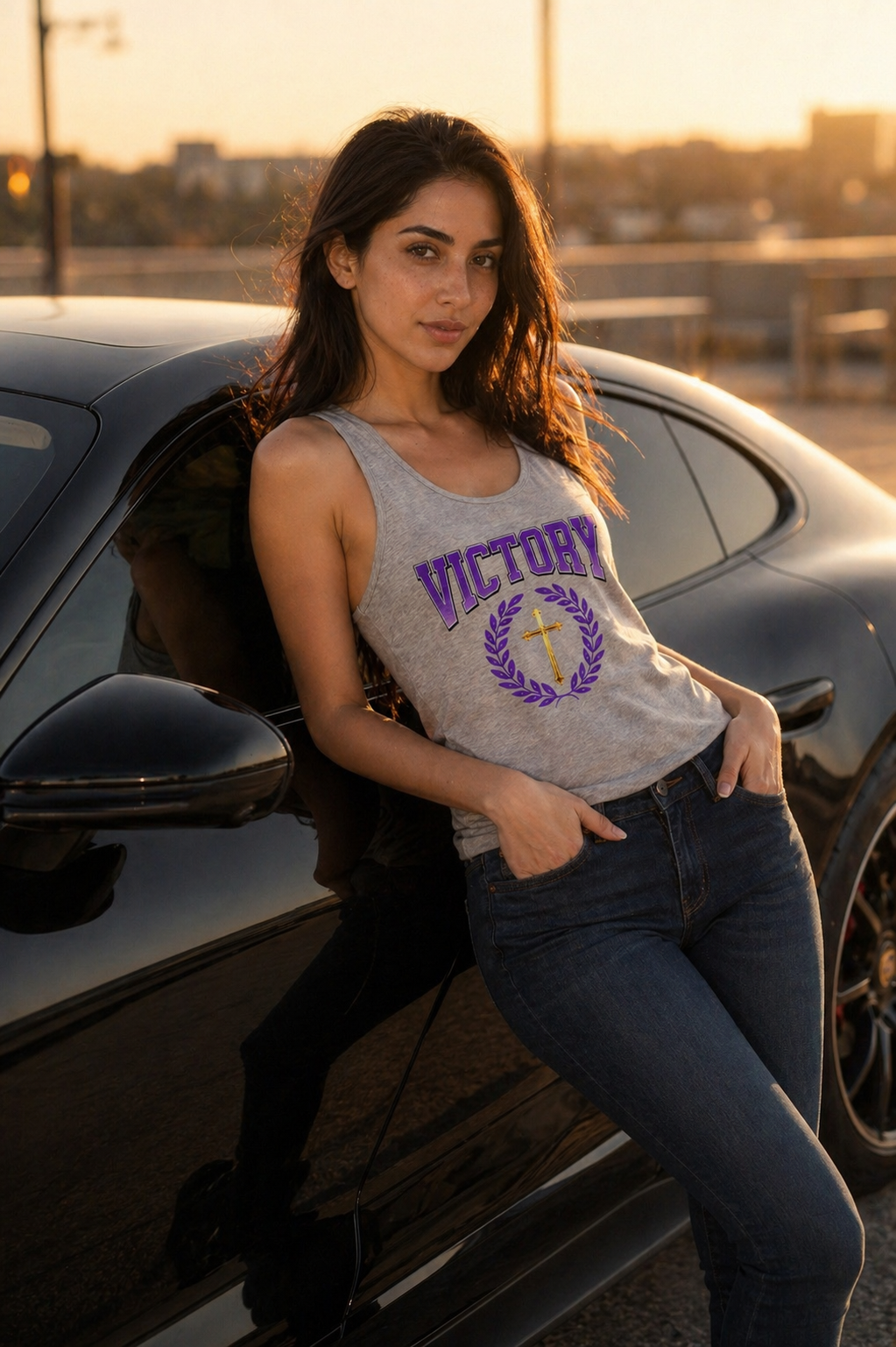 Woman sitting on a car wearing a 'Victory' tank top with a cross design.