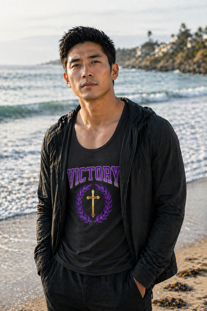 Man wearing a black hoodie and 'Victory' t-shirt with a cross graphic on a beach.