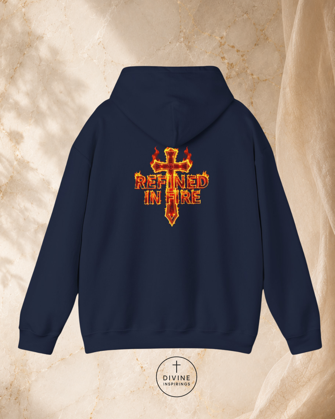 Navy blue hoodie with 'Refined in Fire' design on the back, displayed against a beige marble background.