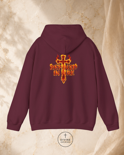 Maroon hoodie with 'Refined in Fire' design on the back against a beige marble background.