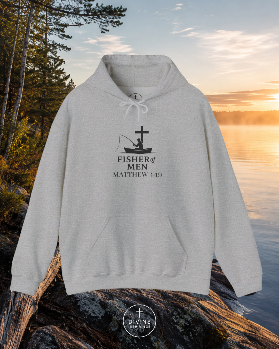 Gray hoodie with a fishing graphic and text on a rock by a lake at sunset