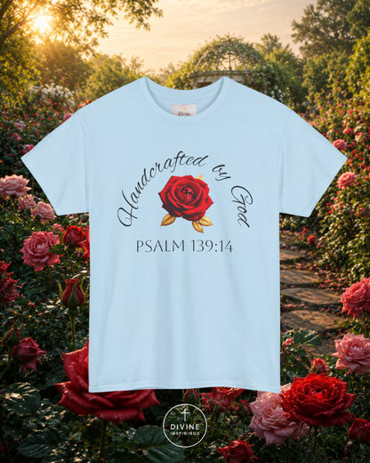 Light blue t-shirt with red rose graphic and text in a garden setting