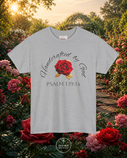 Light blue t-shirt with red rose graphic and text in a garden setting