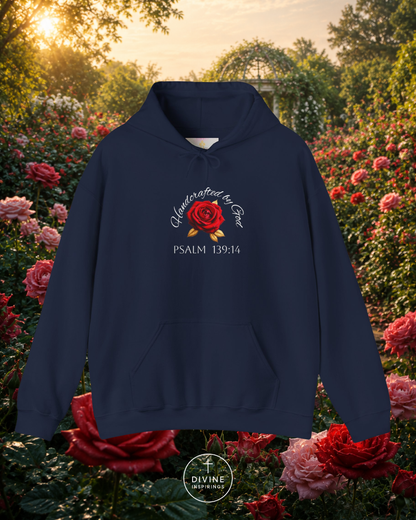 Navy blue hoodie with floral design and text in a garden setting