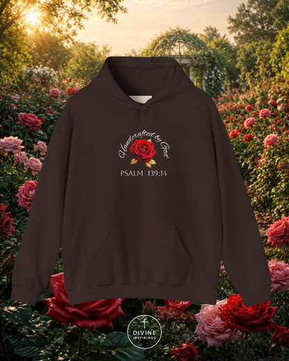 Brown hoodie with a rose design and text in a garden setting