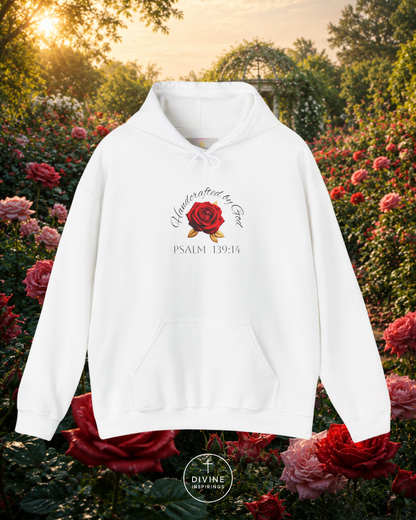 White hoodie with a rose design and text in a garden setting