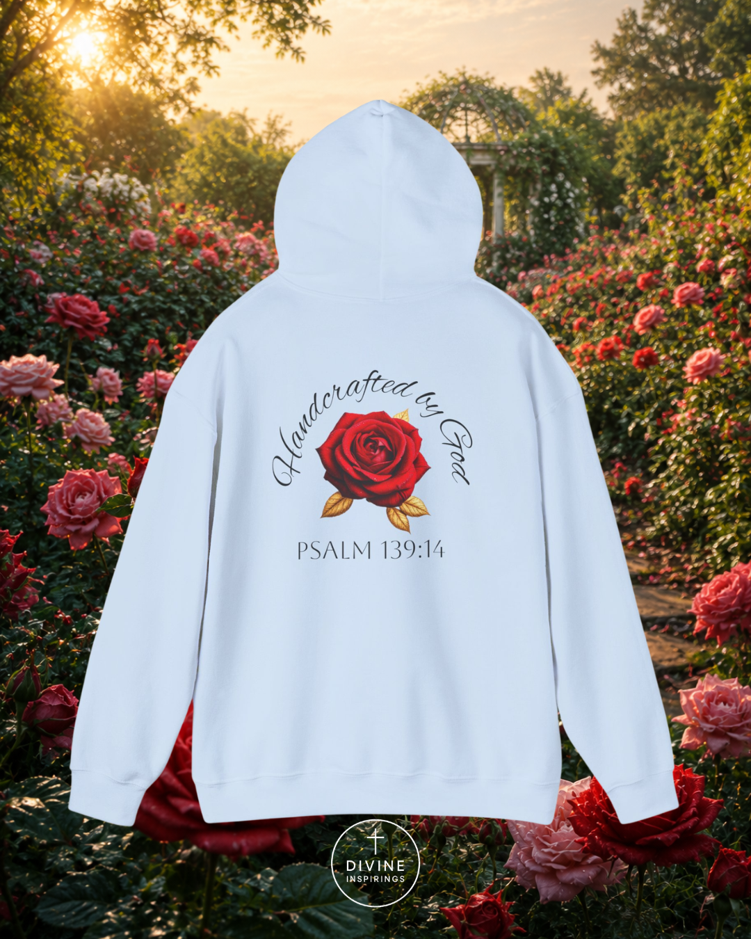 White hoodie with a red rose design and text in a garden setting