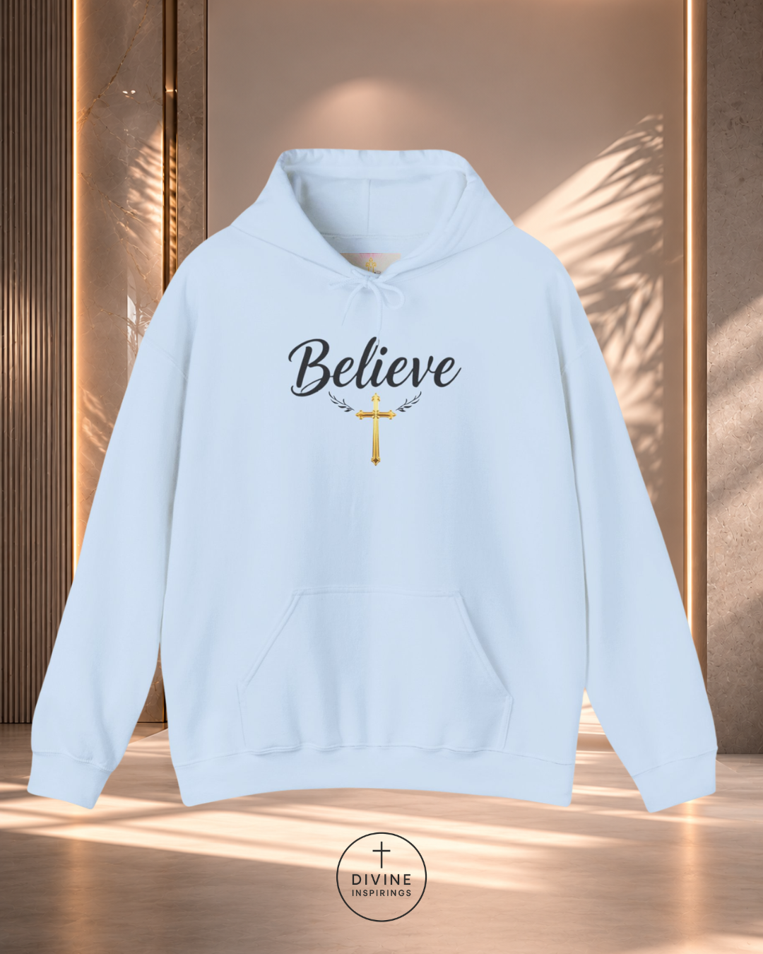 Light blue hoodie with 'Believe' text and cross design on a wooden background