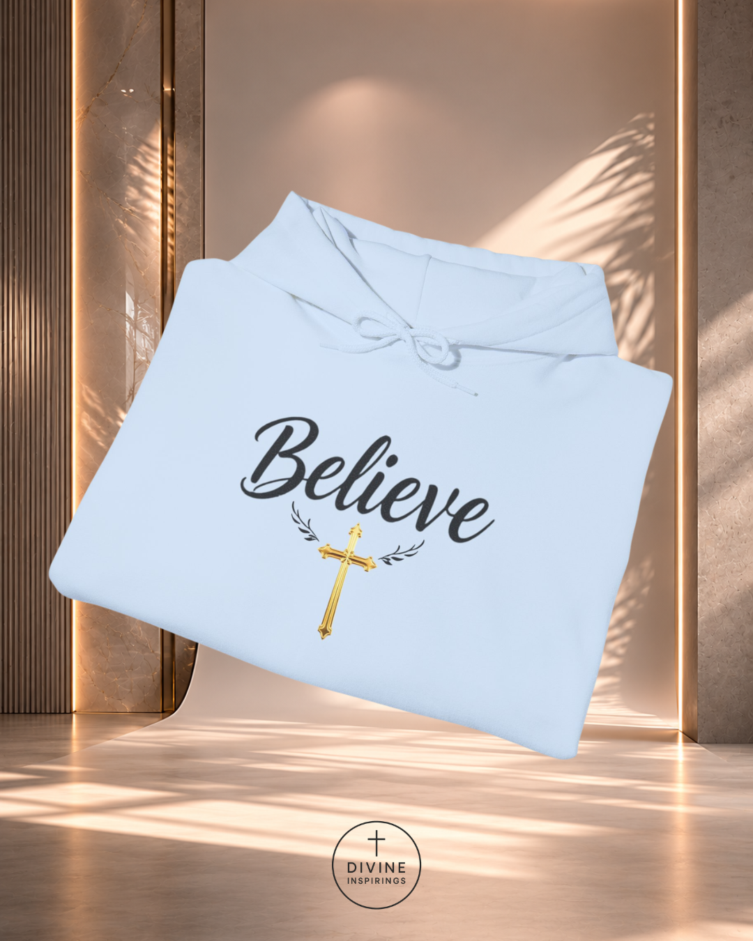 Light blue hoodie with 'Believe' text and cross design on a wooden background