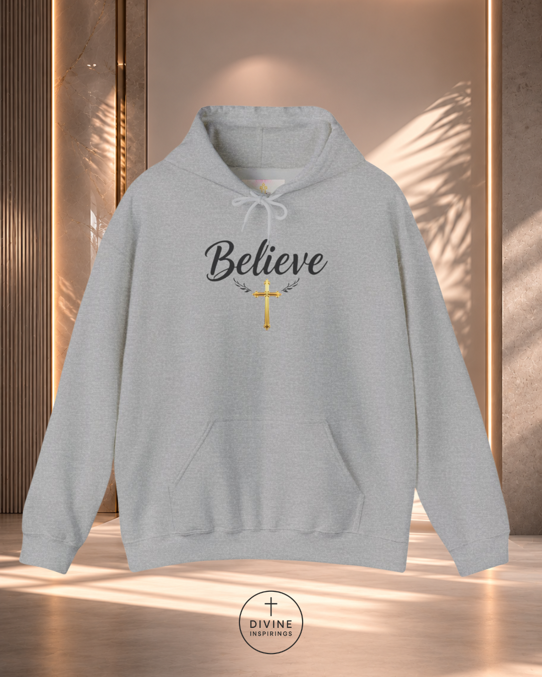 Gray hoodie with 'Believe' and cross design on a neutral background