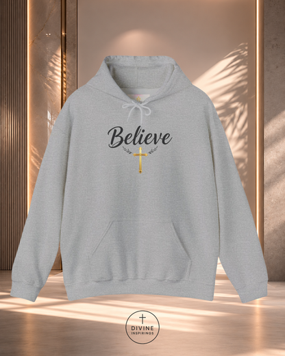 Gray hoodie with 'Believe' and cross design on a neutral background