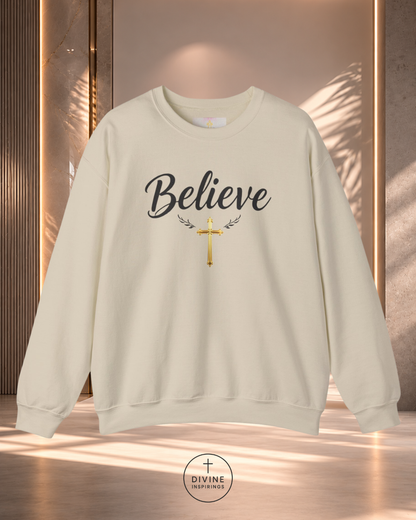 Beige sweatshirt with 'Believe' text and cross design on a neutral background