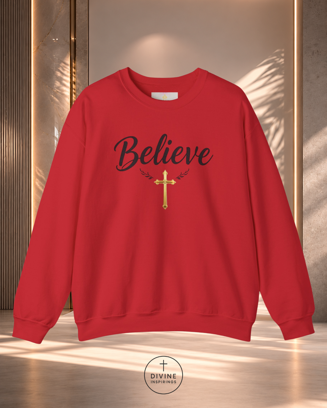 Red sweatshirt with 'Believe' and a cross design on a neutral background