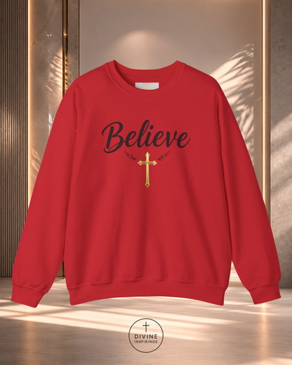 Red sweatshirt with 'Believe' and a cross design on a neutral background