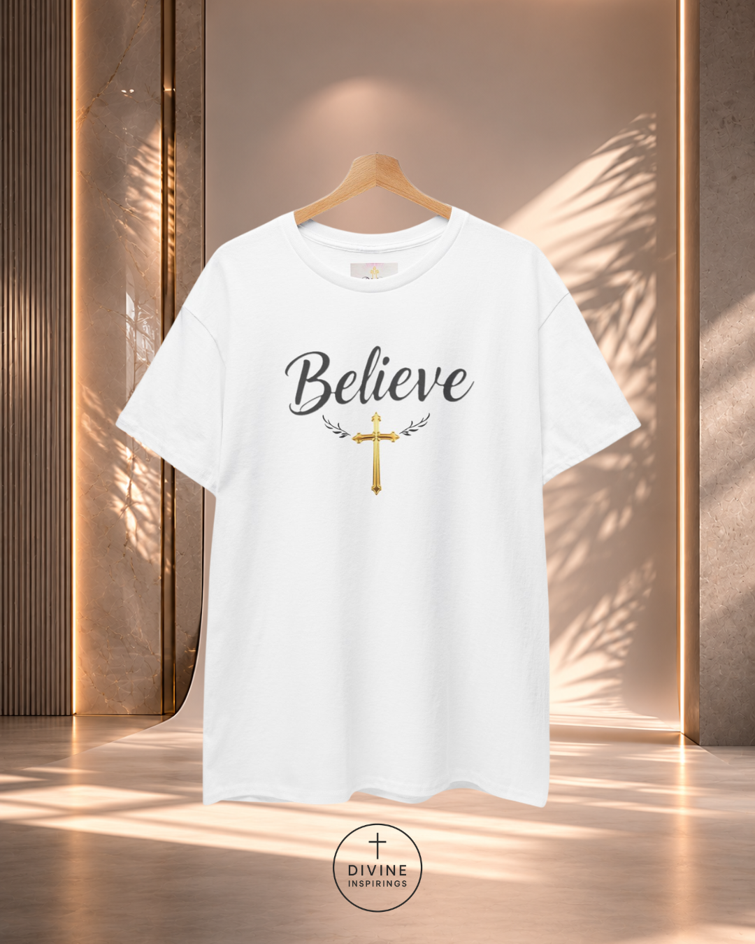 White t-shirt with 'Believe' and cross design on a hanger against a neutral background