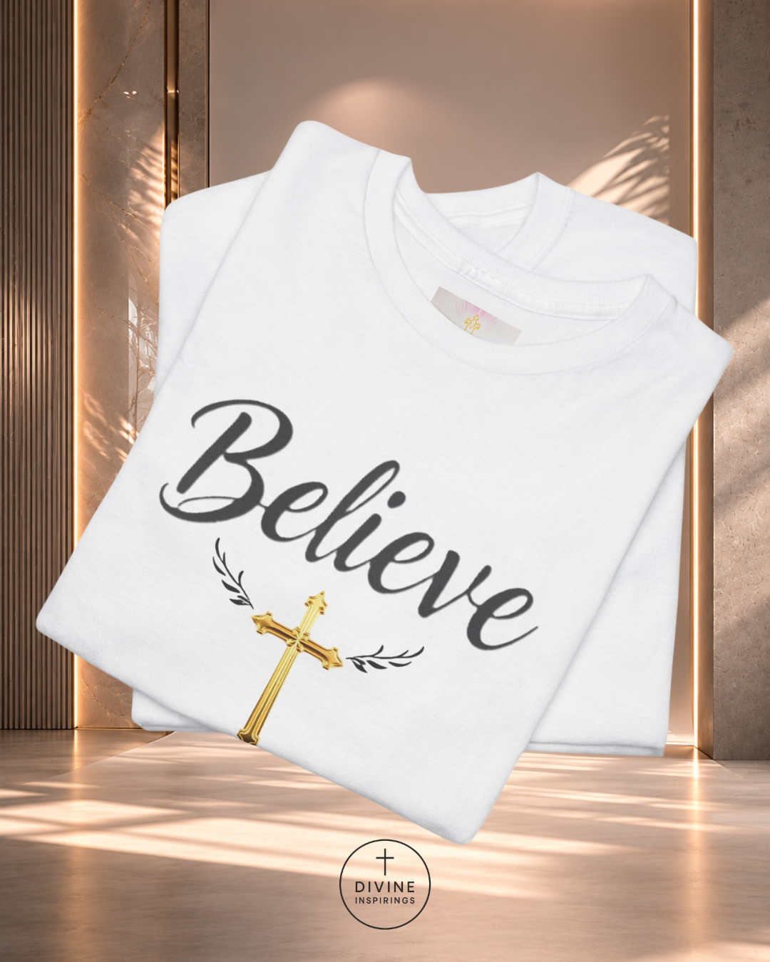 White sweatshirt with 'Believe' text and gold cross on a wooden surface