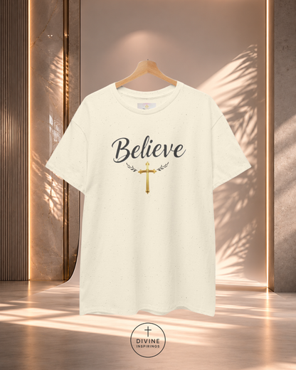White t-shirt with 'Believe' and cross design on a hanger against a neutral background