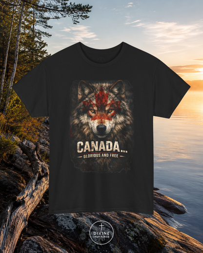 Black t-shirt with a wolf graphic and 'Canada Glorious and Free' text, placed on rocks by a lake.