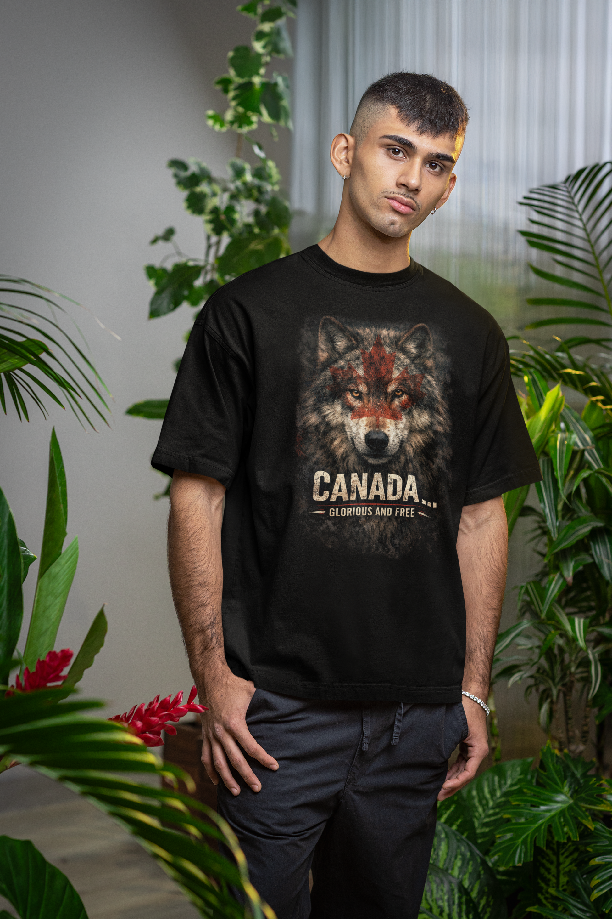 Person wearing a black t-shirt with a wolf graphic and 'Canada' text, standing among plants.