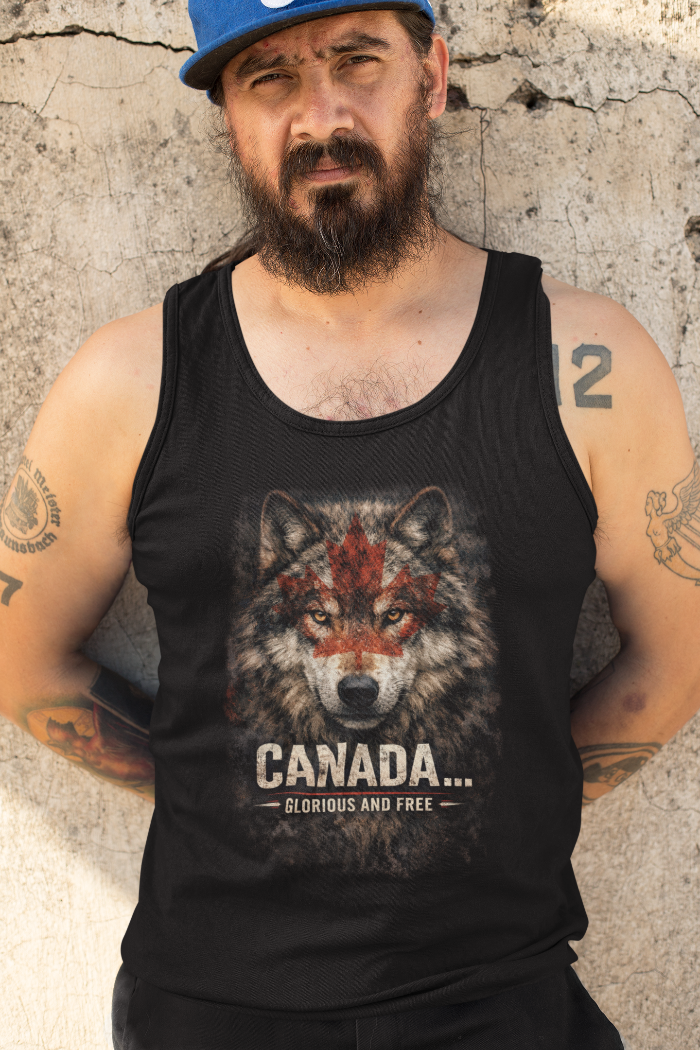 Man wearing a black tank top with a wolf graphic and 'Canada' text against a textured wall.