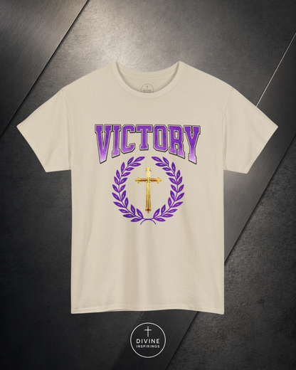 Beige t-shirt with 'VICTORY' text and cross design on a dark surface