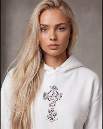 Woman wearing a white hoodie with a black cross design on a neutral background